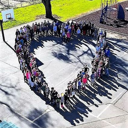 Birds eye view of students standing in the shape of a heart